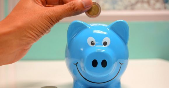 Investment Glossary. - Person Putting Coin in a Piggy Bank