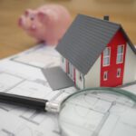 Investment Basics - white and red wooden house beside grey framed magnifying glass