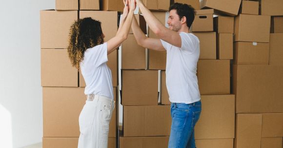 Good Investment. - Smiling couple giving high five after moving into new house