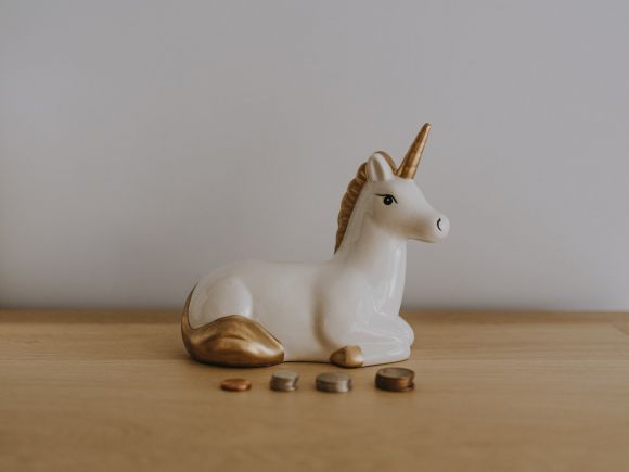 Investment Basics - white and gold ceramic unicorn figurine near coins